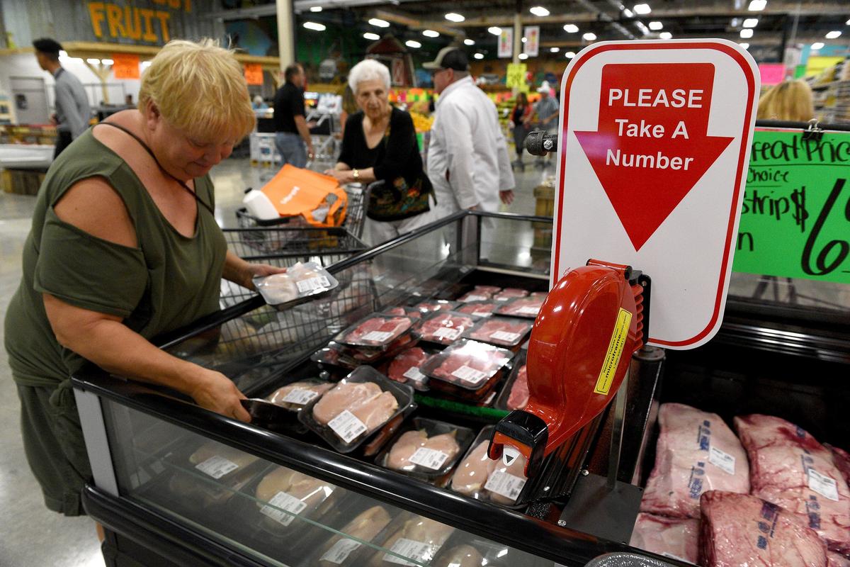 Customers peruse a fridge full of meats at the new Detwiler’s Farm Market in Palmetto.