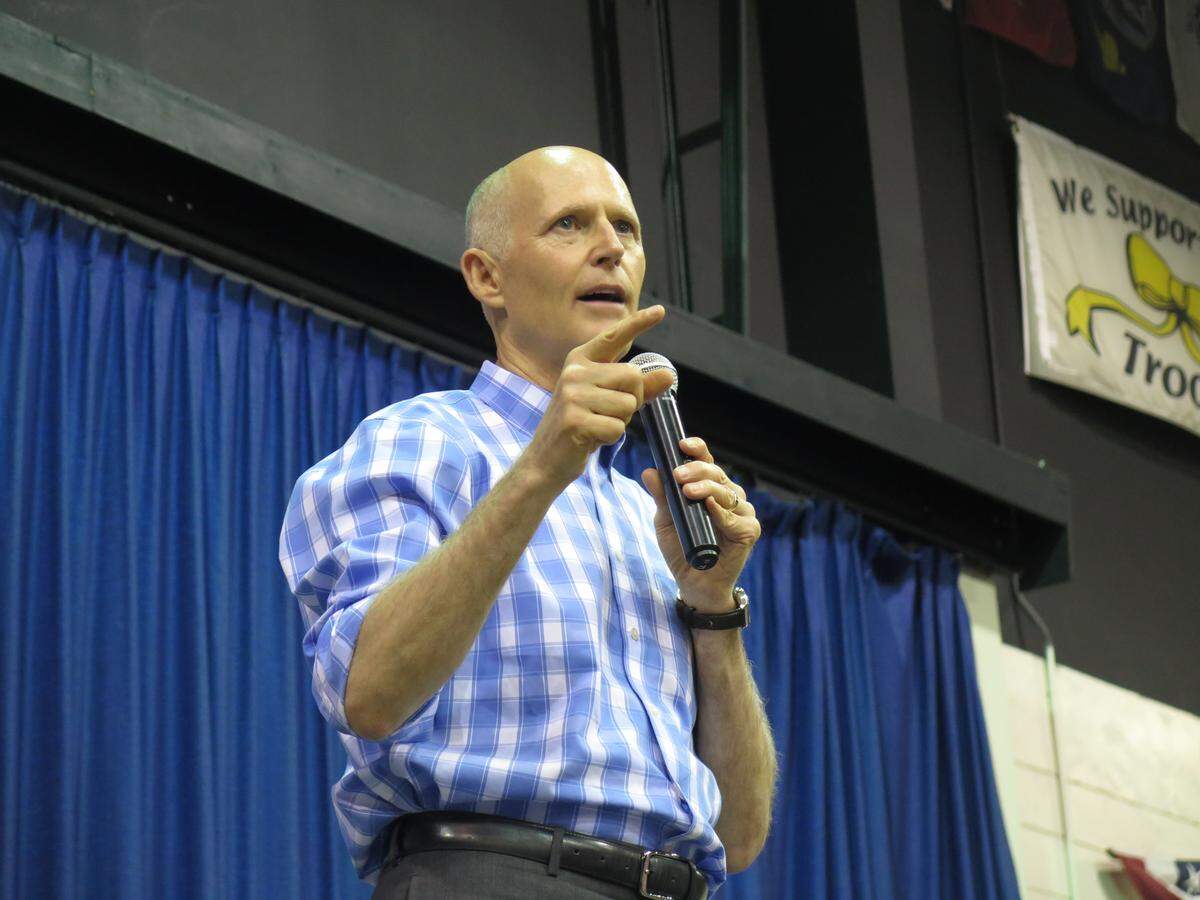 Gov. Rick Scott, a candidate for a U.S. Senate seat, spoke at Saturday’s rally in Sarasota. He was interrupted by hecklers who accused him of using “blood money.” He and potential voters drowned out the demonstrators with chants of “USA!” as officers removed the protestors from the building.
