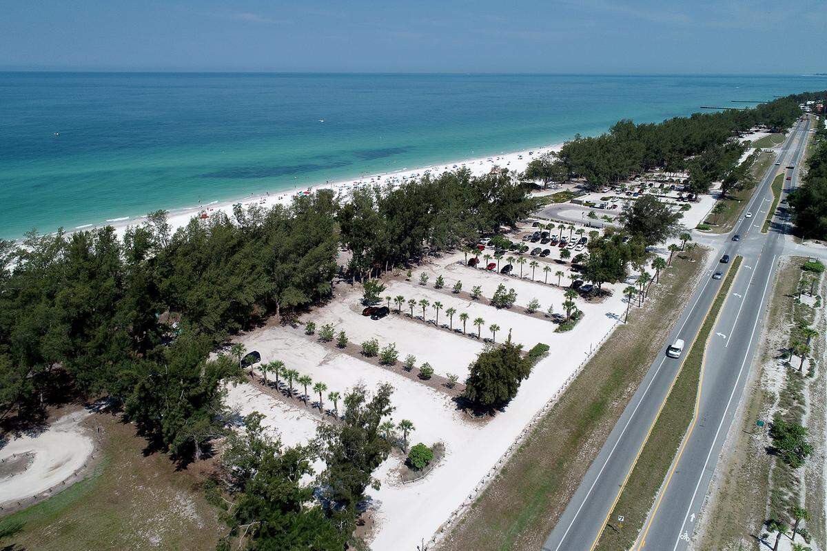 The Board of County Commissioners voted 4-2 to continue a controversial Coquina Beach parking lot improvement project that may have to remove up to 230 trees from the area.