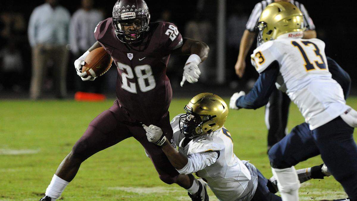 Braden River's Deshaun Fenwick runs the ball as St. Thomas Aquinas' Nik Bonitto tries to stop him in the class 7A state semifinals. Aquinas, a private school, won its ninth straight state championship a week after defeating public school Braden River. . 
 TIFFANY TOMPKINS-CONDIE/Bradenton Herald