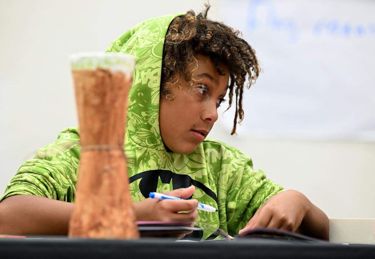 Markell Thomas looks up while coloring his Juneteenth flag Friday at the Manatee County Central Library.