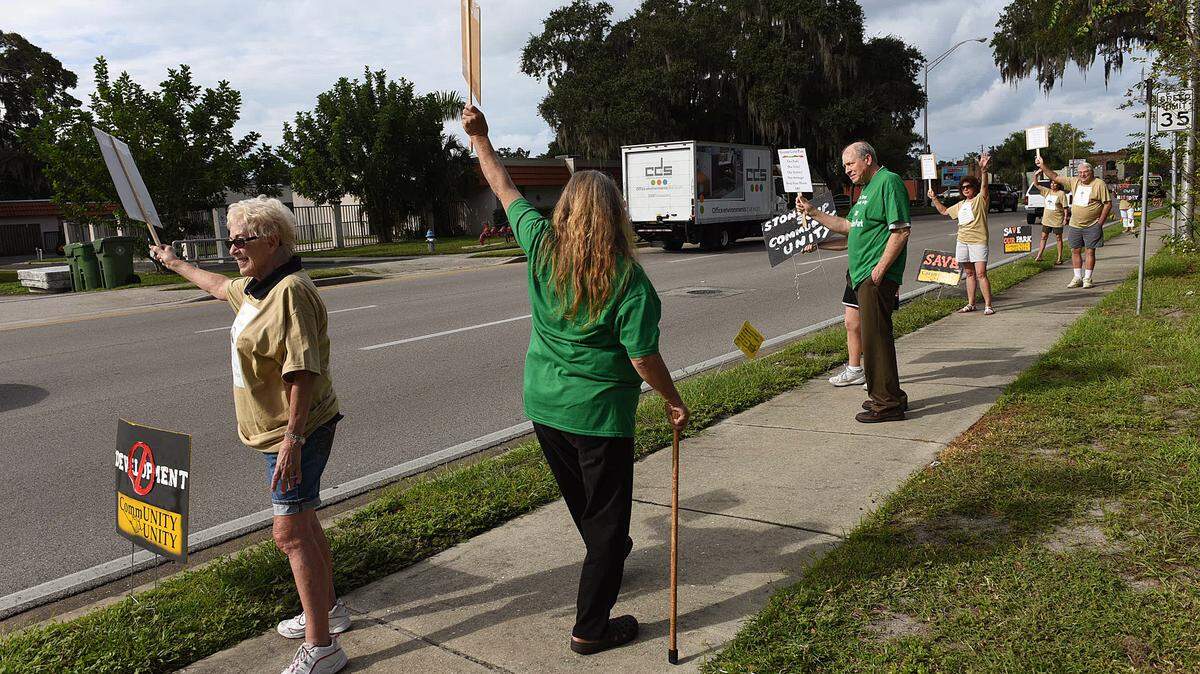 A group of protestors against the development of Glazier Gates Park in Bradenton hold signs and wave to passing cars in October 2015. 
 TIFFANY TOMPKINS-CONDIE/Bradenton Herald