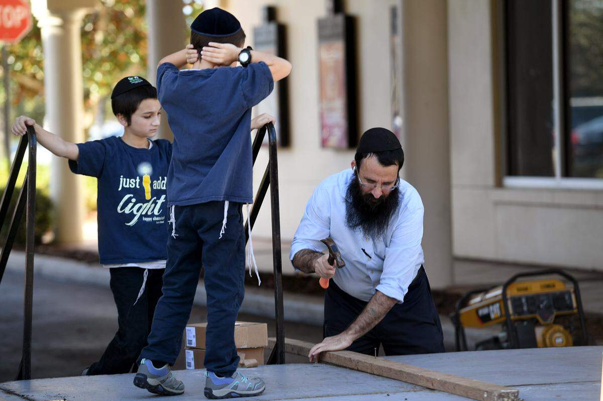 Rabbi Mendy Bukiet of the Chabad of Bradenton and Lakewood Ranch sets up what will be a large menorah for a celebration of the second night of Hanukkah on Lakewood Ranch Main Street.