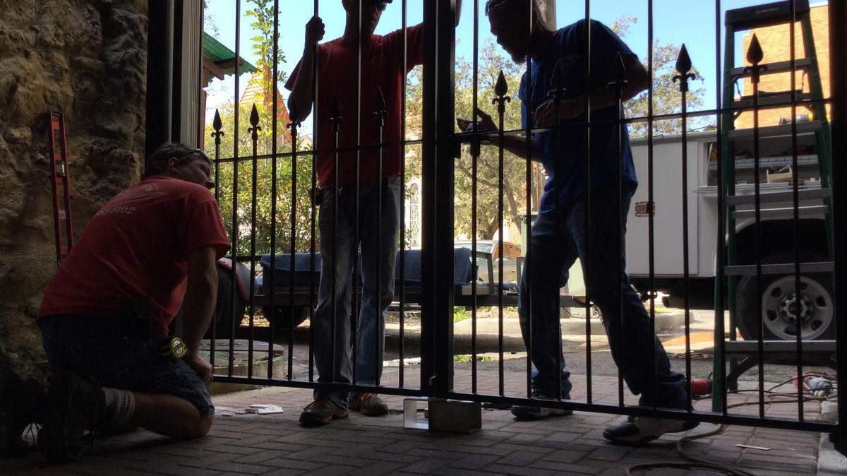 Workers from Sarasota-based Rail-Tek Inc. install two custom designed steel welded gates at both ends of the alleyway in the 400 block of Old Main Street on Tuesday. The Bradenton Downtown Development Authority approved $11,000 several months ago to curb unsavory activities that had been taken place in the alley during late night hours. MARK YOUNG/Bradenton Herald