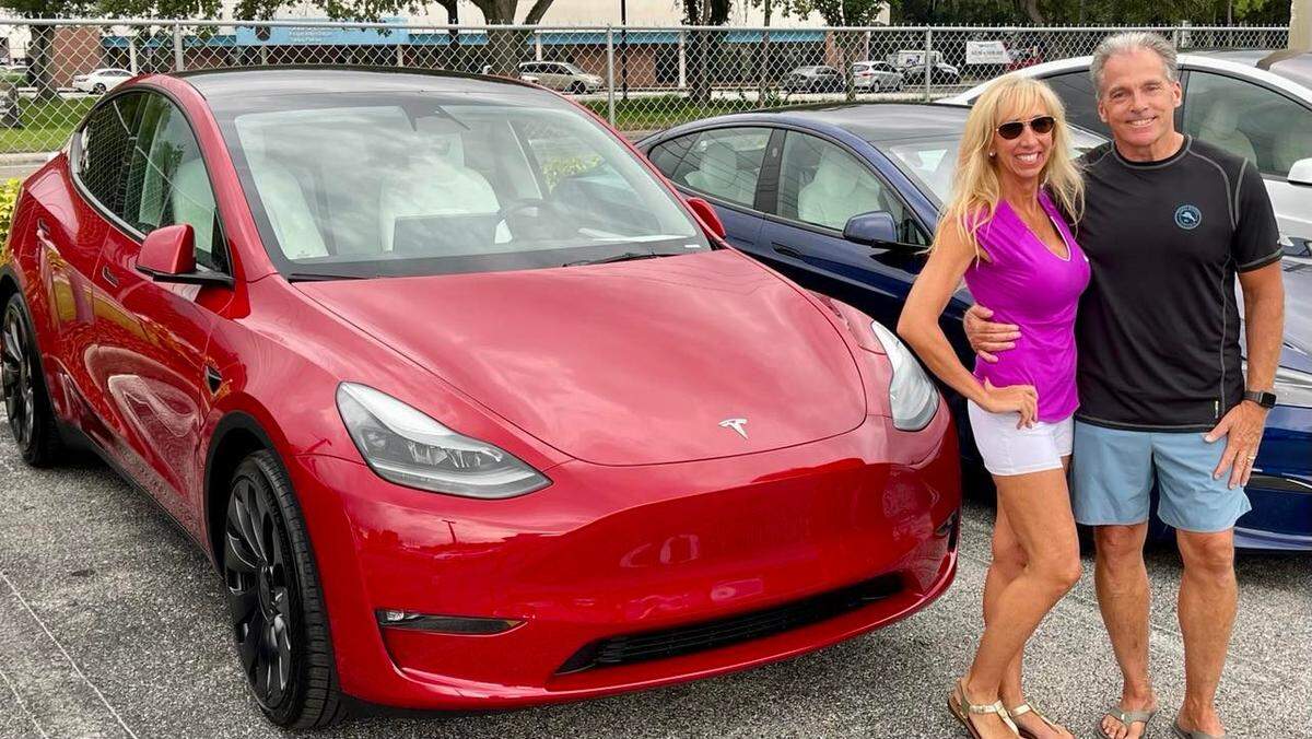 Carol Burdelik and her husband Michael stand in front of their new Tesla Y Performance. Three days before two men stole the license plate from their vehicle while out together having dinner , Sept. 7, 2022.