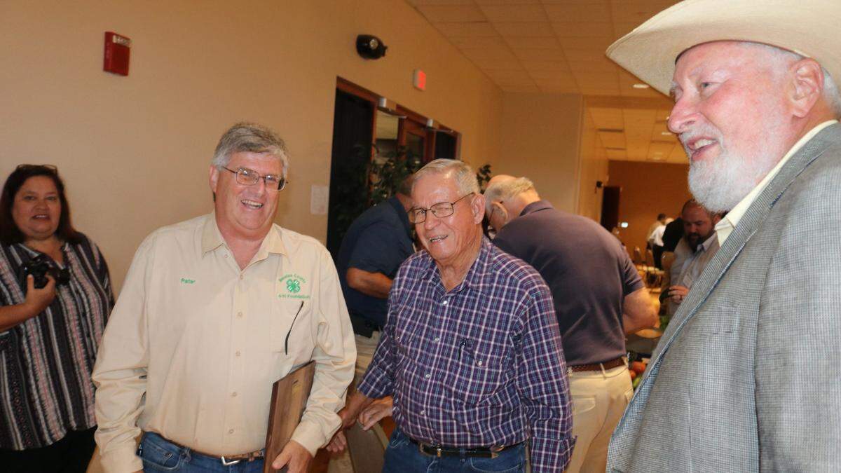Peter Vole III, left, 2022 Manatee County Agriculturist of the Year, accepts congratulations from previous recipients Cully Rowell, center, and Ralph Garrison, right. At left behind Vole is Patty Keen-Freed, chair of Manatee County Farm City Week.