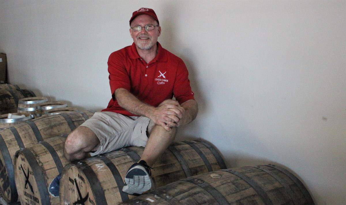 Steve Milligan sits on some of the barrels used to age spirits at Loaded Cannon Distillery. The new business opens July 19, at Lakewood Ranch.