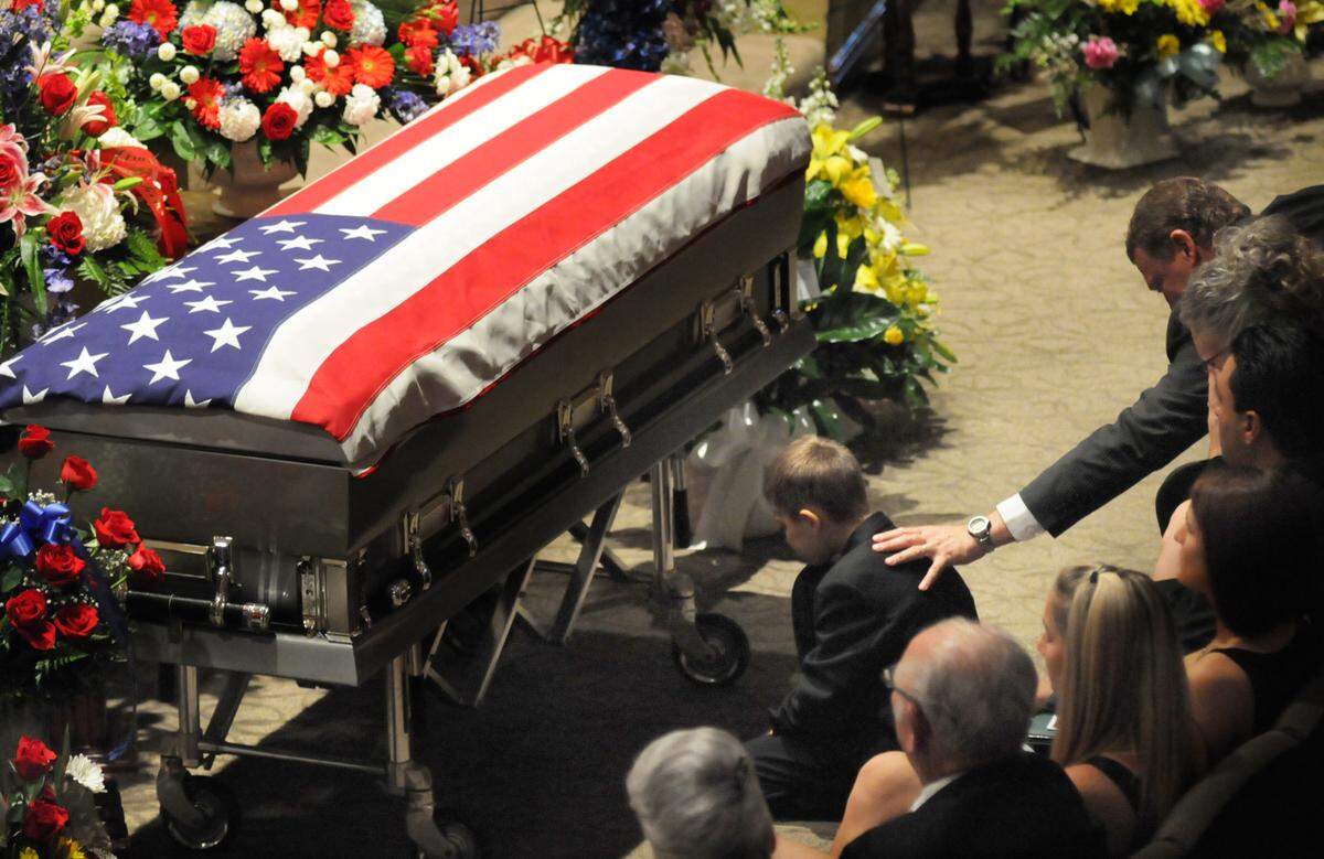 A young boy kneels at the casket of U.S. Army Spc. Patrick Lay during a “Going Home” service on Sunday, Aug. 21, 2011, at the Life Covenant Church. Lay died Aug. 11 while serving in Afghanistan.