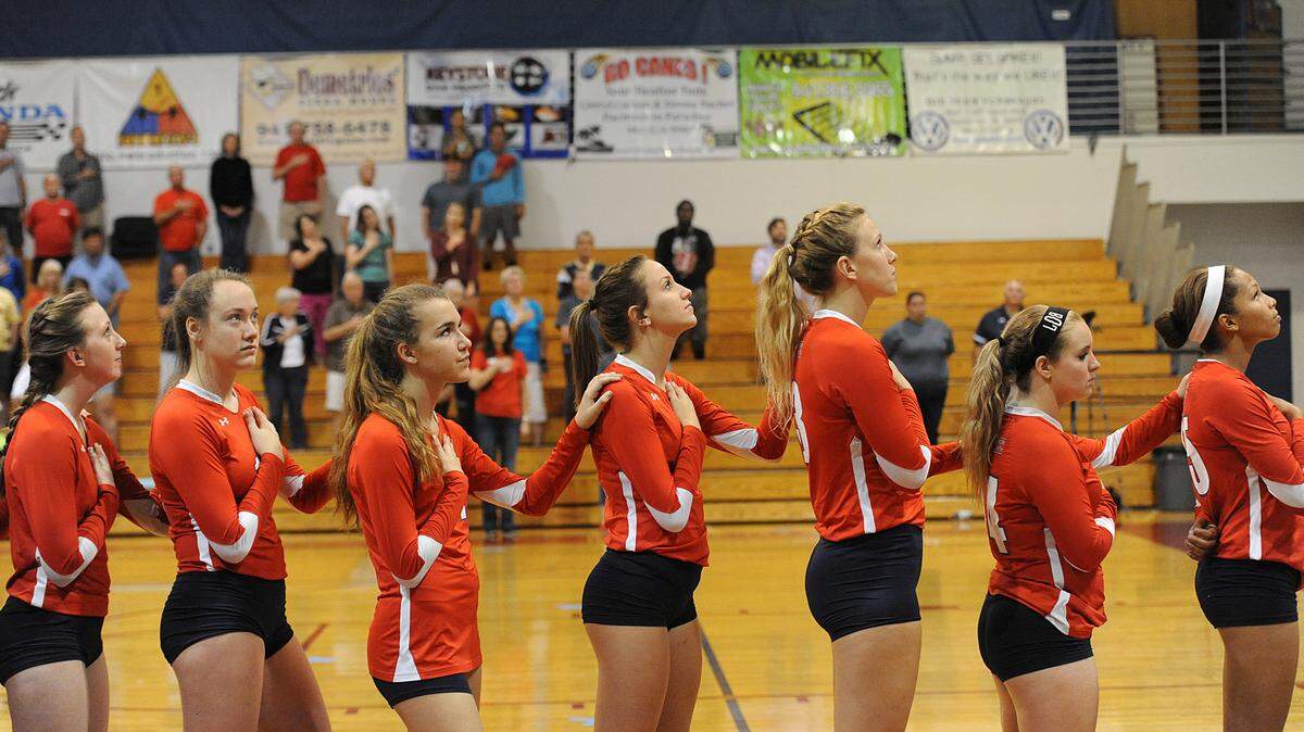 Manatee's volleyball team stands for the national anthem before the regional volleyball district quarterfinal against Cypress Creek Wednesday night. 
 TIFFANY TOMPKINS-CONDIE/Bradenton Herald