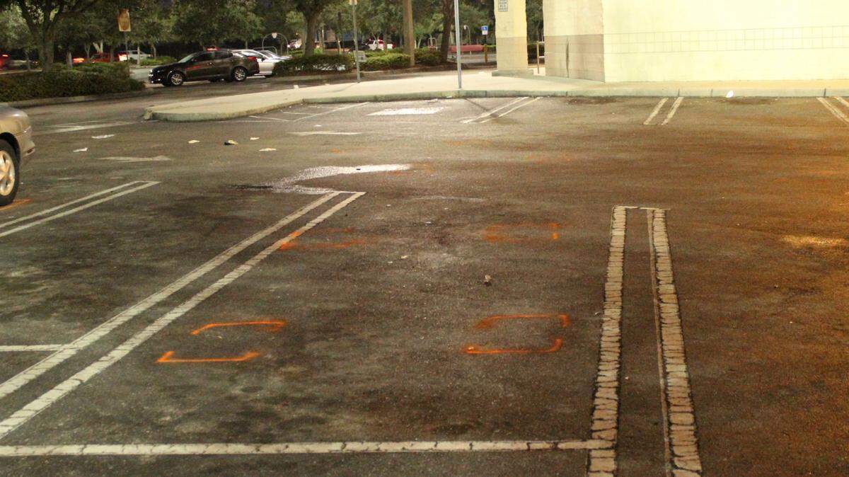Orange brackets on a supermarket parking lot mark the spot where a deputy fatally shot a 33-year-old man during a confrontation early Thursday. 
 JAMES A. JONES JR./Bradenton Herald
