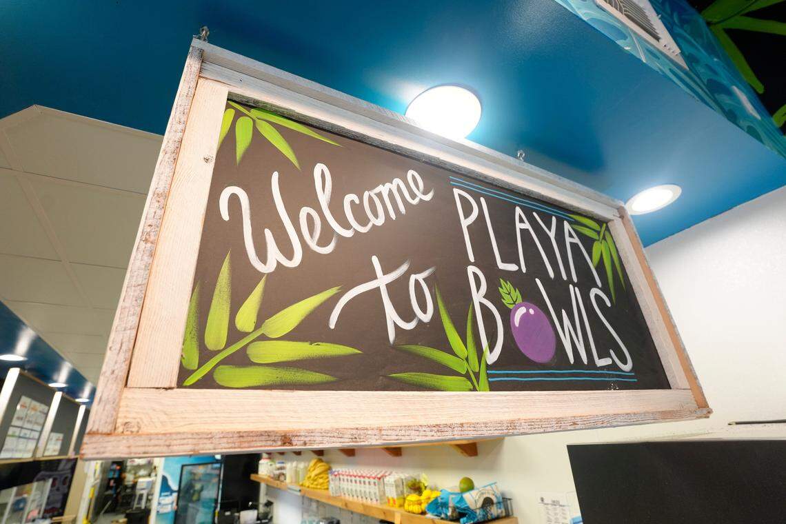 A welcome sign at Playa Bowls located in the Beechwood Shopping Center on Wednesday, August 6, 2025. The shop offers up tropical fruit bowls, fresh squeezed juice and smoothies inspired from its creators travels in the Caribbean, Central America and Hawaii.