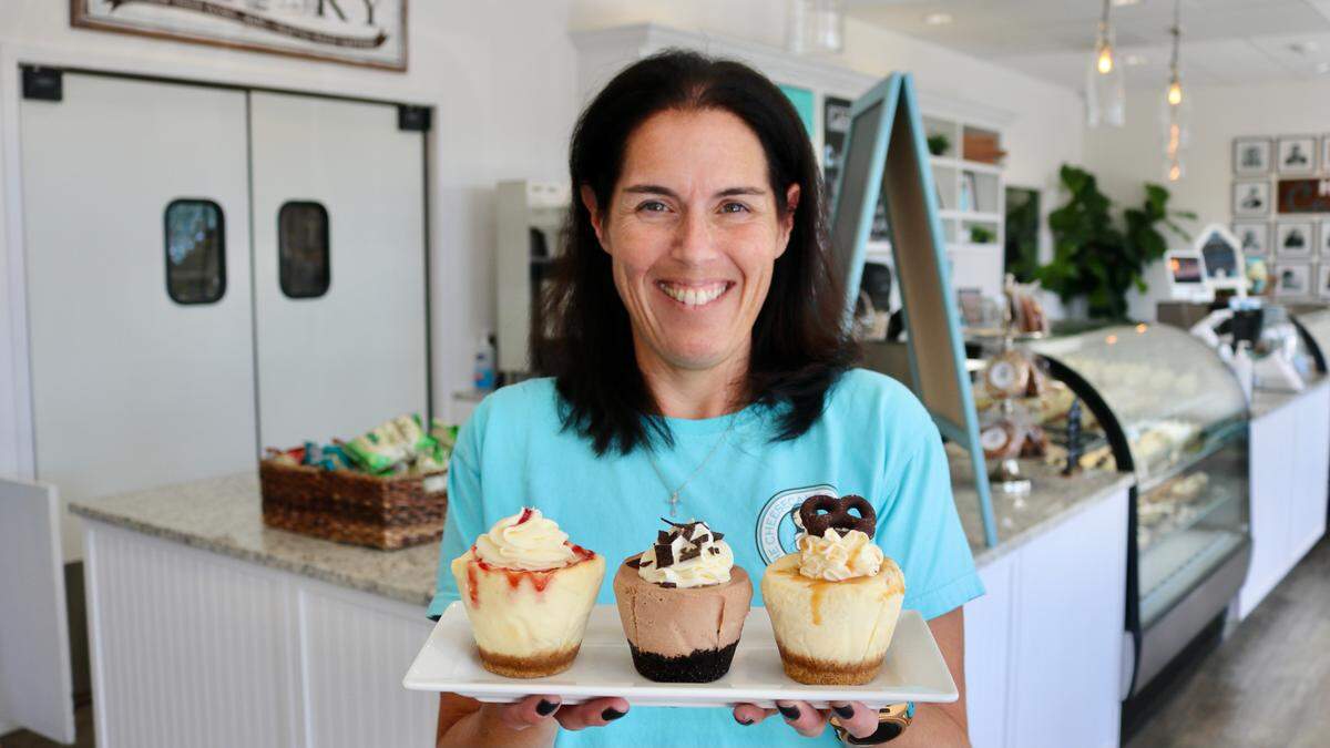 6/1/2021--The Cheesecake Cutie & Cafe opened at 3324 E. Bay Drive, Holmes Beach, in November. In addition to its cheesecakes, the cafe is now serving breakfast and lunch. Shown above is owner Jennifer Geils with some of her cheesecake cuties, which are also available in a wide variety of full-size cheesecakes.