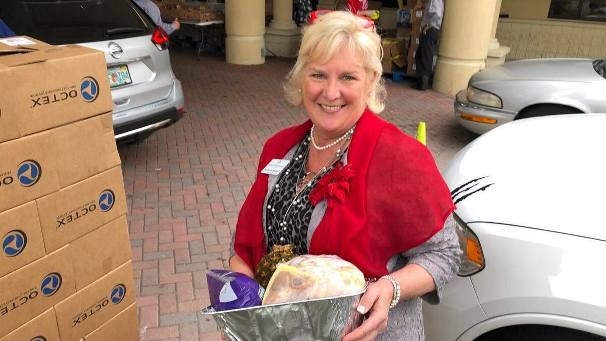 12/20/2021--Meals on Wheels PLUS of Manatee volunteers distributed hams, canned vegetables, and all the fixings to 500 Bradenton area families this week to help them prepare a traditional holiday meal at home. Shown above is Maribeth Phillips, CEO and president of the nonprofit.