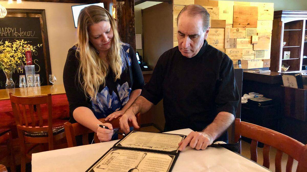 Dean Donnelly and Michele Angell look over the menu at Mean Deans Local Kitchen, 6059 26th St. W., Bradenton. The new neighborhood restaurant opened Nov. 17.