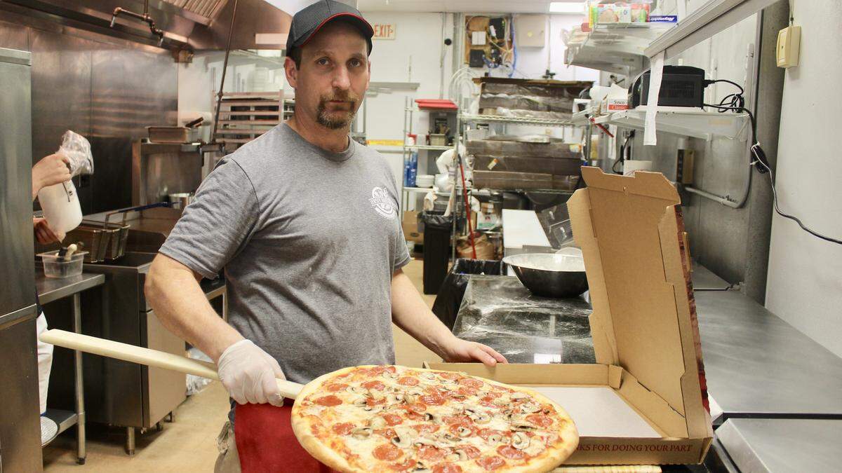 Bill Nehila prepare to box a freshly baked pepperoni and mushroom pizza at Jersey Brothers Pizza and Pasta, located in Ranch Lake Plaza.