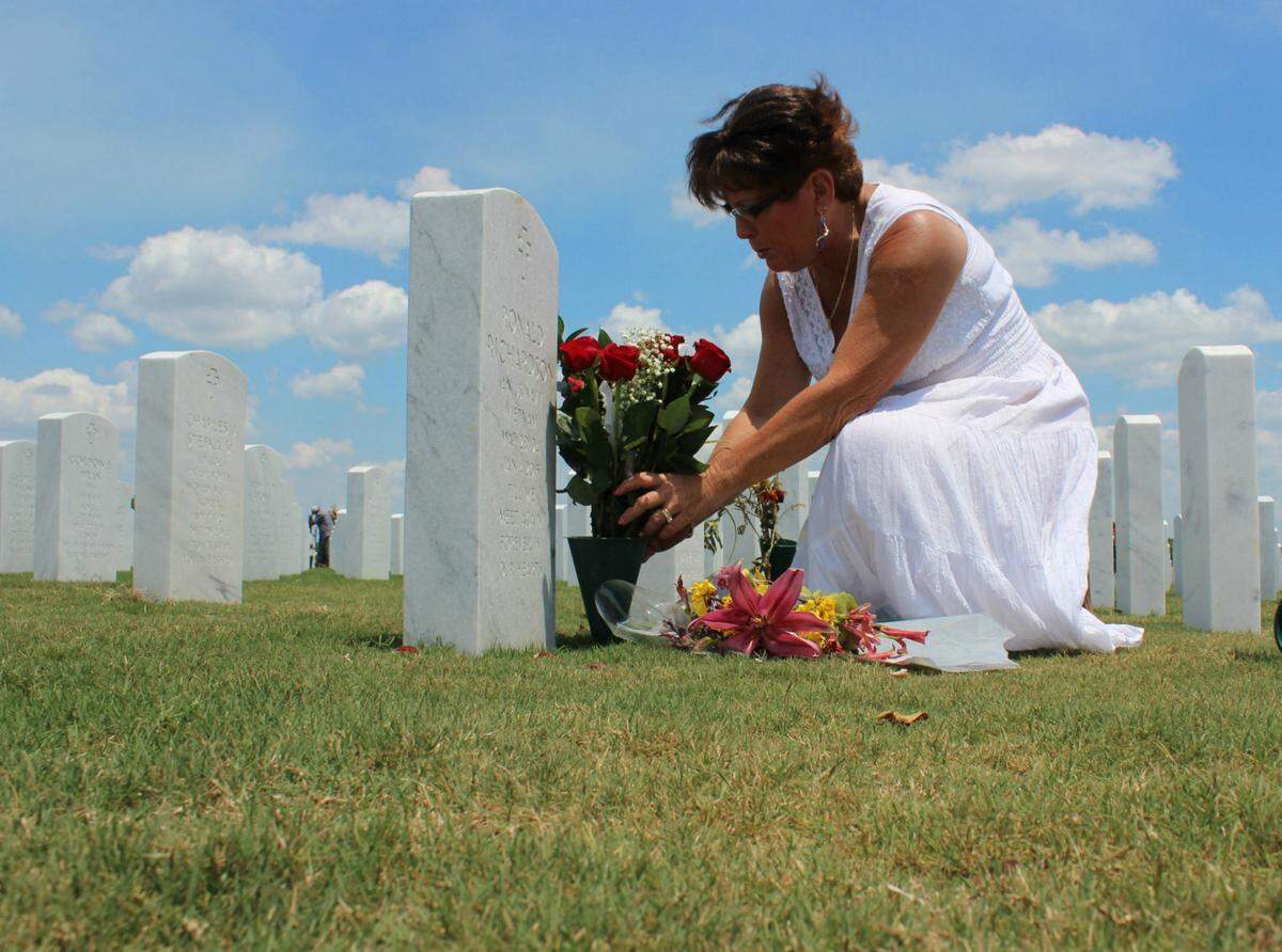Despite the challenges of the COVID-19 pandemic,&nbsp; Wreaths Across America is moving ahead with the December tradition of decorating every grave at Sarasota National Cemetery.  Meshia Richardson, who coordinates the local effort, is shown in 2016 placing flowers at her husband’s grave site.