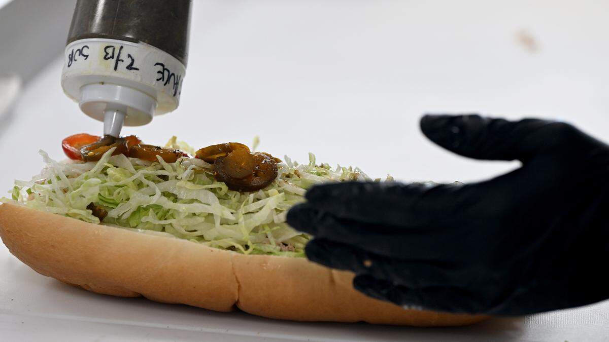 An employee adds sub sauce to a sandwich as he prepares an order at Gateway Subs. The restaurant is open at 2215 60th Ave. E., Ellenton. Photo taken July 15, 2025.