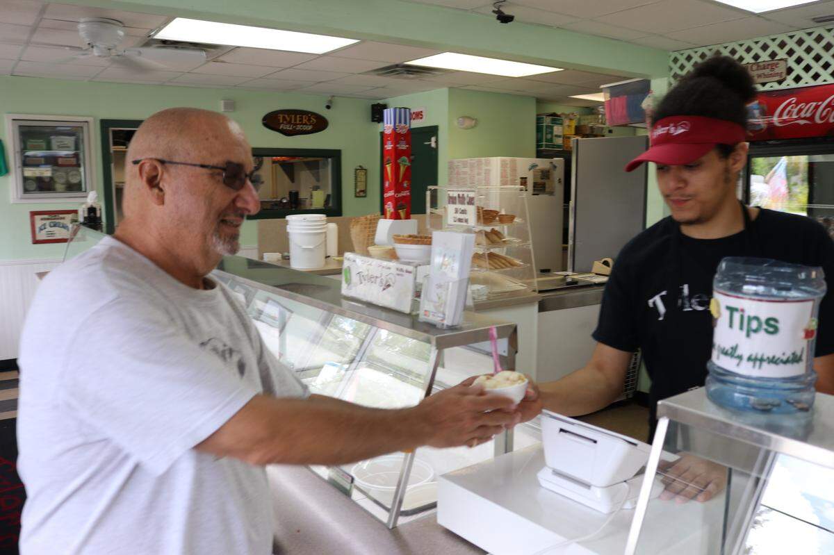 Tom Ehren, left,  stopped at Tyler’s Ice Cream, 11904 Cortez Road W., for a cup of nutty caramel. Also shown is Miguel Ortiz.