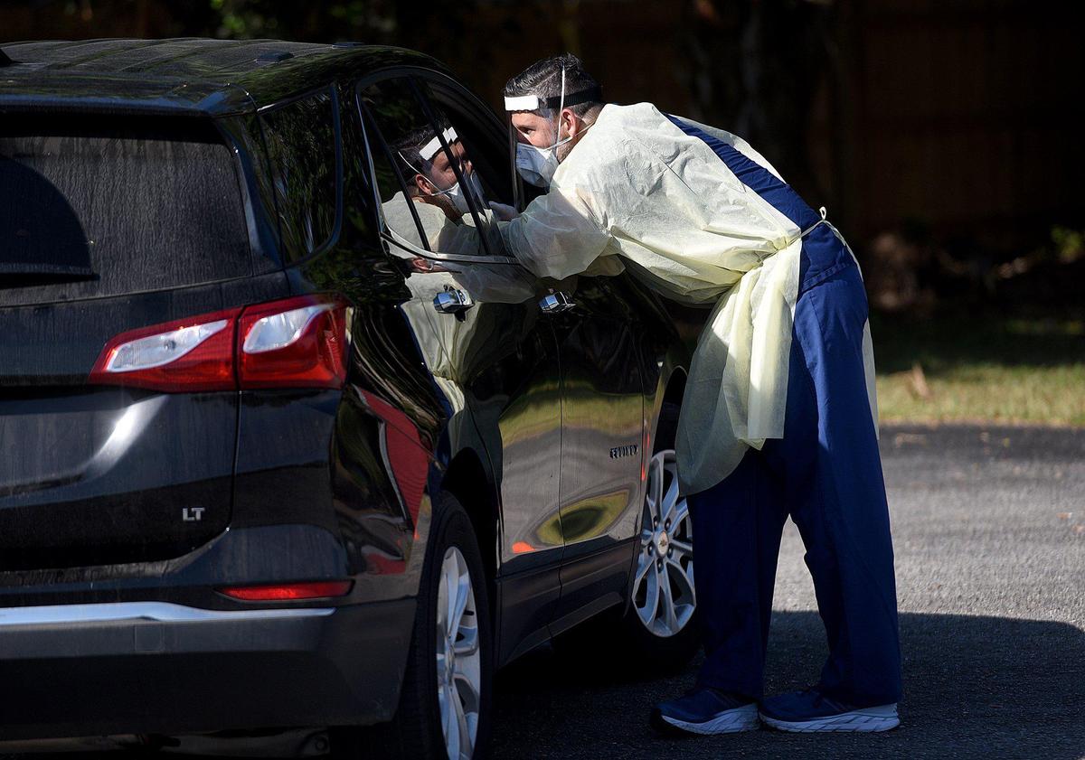 Alexander Petreas, Physician’s Assistant at Ellenton Urgent Care, tests people for coronavirus in a drive-thru set up next to their offices.