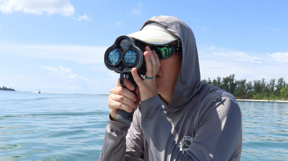 A researcher from Mote Marine Laboratory measures the speed of a passing boat in Sarasota Bay on Thursday, Sept. 21, 2023. The data collected is part of Mote’s Sea Turtle Protection Zone initiative.