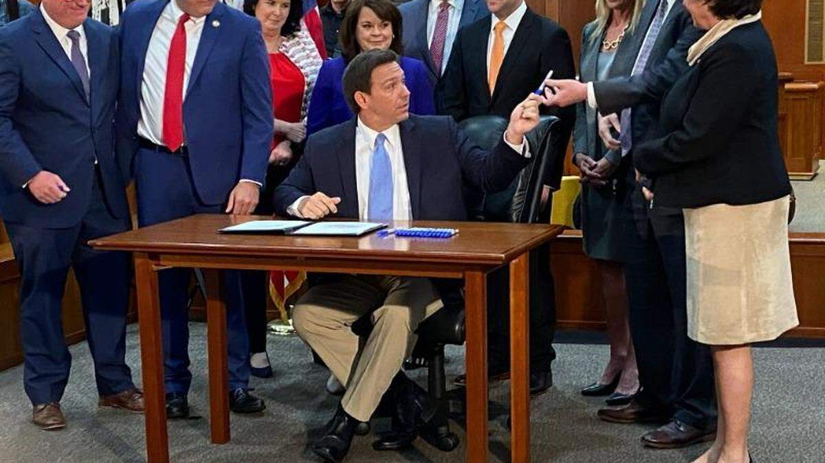 El gobernador de la Florida, Ron DeSantis, firma una ley rodeado de legisladores, en esta foto de archivo.