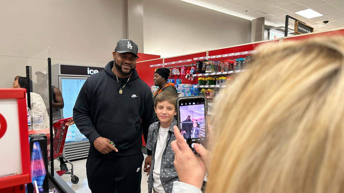 Demarcus Christmas and Nathan Wood, 12, pose for a picture taken by Wood’s mom before checking out at Target on Sunday. Wood was excited to buy a lava lamp to decorate his room with for Christmas. 12/17/2022