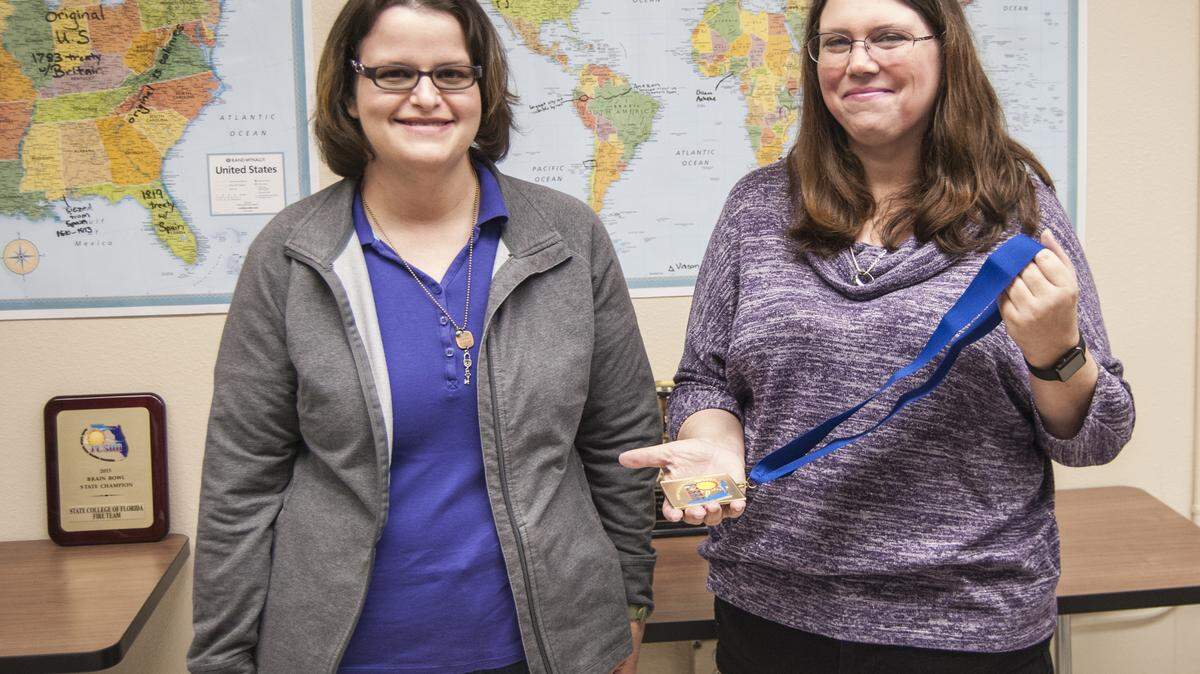Christina Dwyer, SCF Assistant Professor of Mathematics and Brain Bowl Coach, (on right) presents student Ariel Watsky with a medal commemorating her selection as September Brain Bowl Player of the Month by the Florida College System Activities Association.