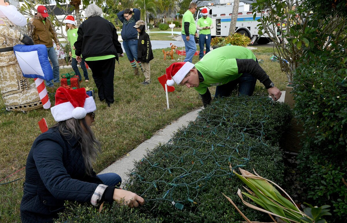 Florida Power and Light volunteers work to decorate and surprise a veteran and his family as a Christmas surprise in Bradenton Monday.