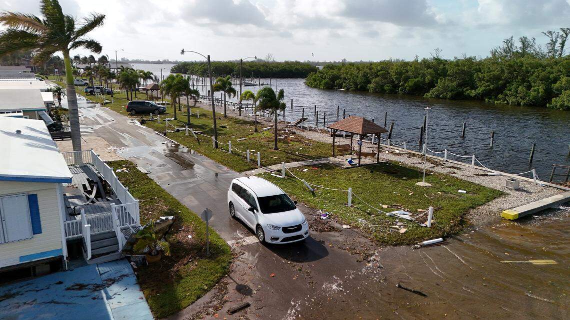 A minivan drives slowly through the destruction of Paradise Bay Estates in the aftermath of Hurricane Helene in Manatee County on Friday, Sept. 27, 2024.