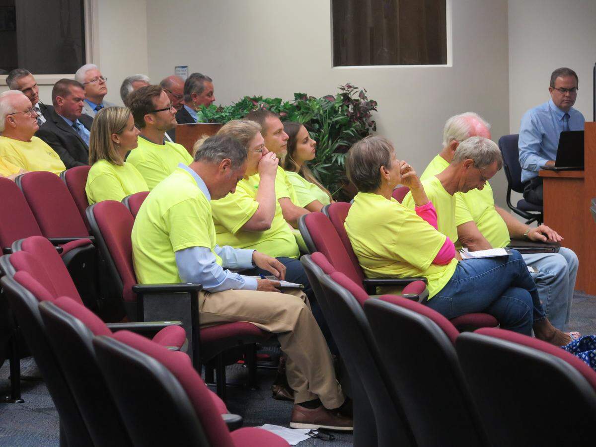 A crowd of about 30 concerned residents wore yellow shirts as they attended Tuesday’s Board of County Commissioners meeting to express their concerns about a 185-foot radio tower that will be built in their neighborhood.