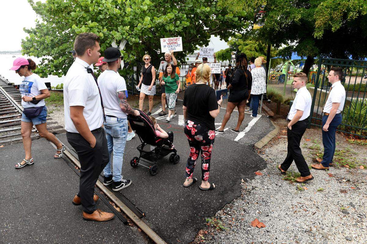 Young men carrying The Book of Mormon pause for marcher to pass during March For Our Futures, an anti-gun violence march and rally organized by Women’s Voices of Southwest Florida, marches from the Riverwalk splash park to Bradenton’s Historic Courthouse.