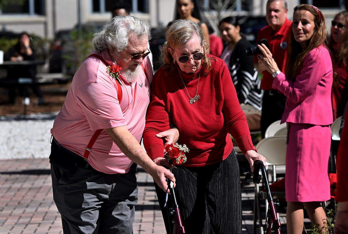 Eleanor Craig, 79 and Norman Rondeau, 80, approach the pergola where six couples married in a wedding celebration beside the Historic Manatee County Courthouse on Feb. 14, 2024.
