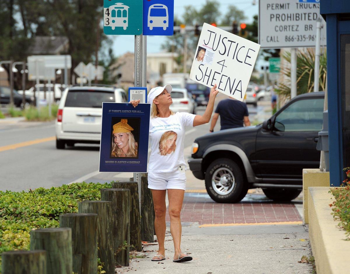 Kelly Osborn protests in front of Bradenton Beach City Hall the closed investigation and findings of the Bradenton Beach Police into the death of her daughter, Sheena Morris, who was found dead in the shower of a motel in 2009. Osborn believes there is evidence that her daughter was murdered and the that the investigation was botched.