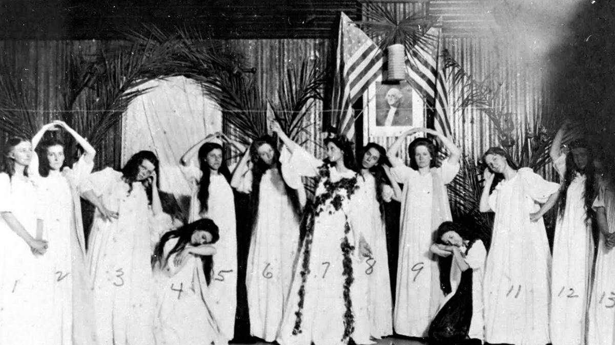 Bradenton Elementary Colored School Play; circa 1951 
 This photo of the Girls in the May Day Play shows the queen, adorned with flowers, attended by girls dressed in white. It was an honor to be chosen May queen. The girls, left to right, are: 1. Lula Hayman 2. May Young 3. Gussie Joe Rowlett 4. Unknown 5. Annie Lamb 6. Clara Booth 7. Eva Jones-Weatherall 8. Eva Albriton 9. Callie Robinson and Nos. 10 through 13 are unidentified.