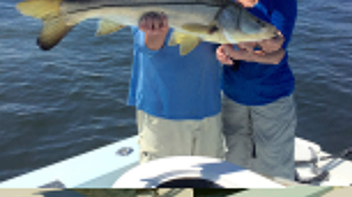 Capt. Scott Moore and Ann Henderson hold up a 40-inch snook caught in the Gulf. PROVIDED PHOTO