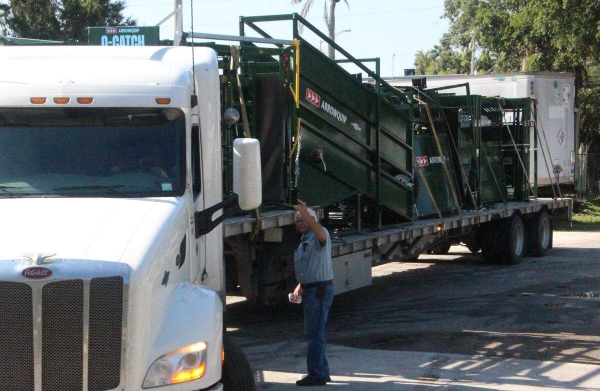 Jim Parks assists a driver delivering a load of cattle chutes and other equipment to Come See Come Sav.