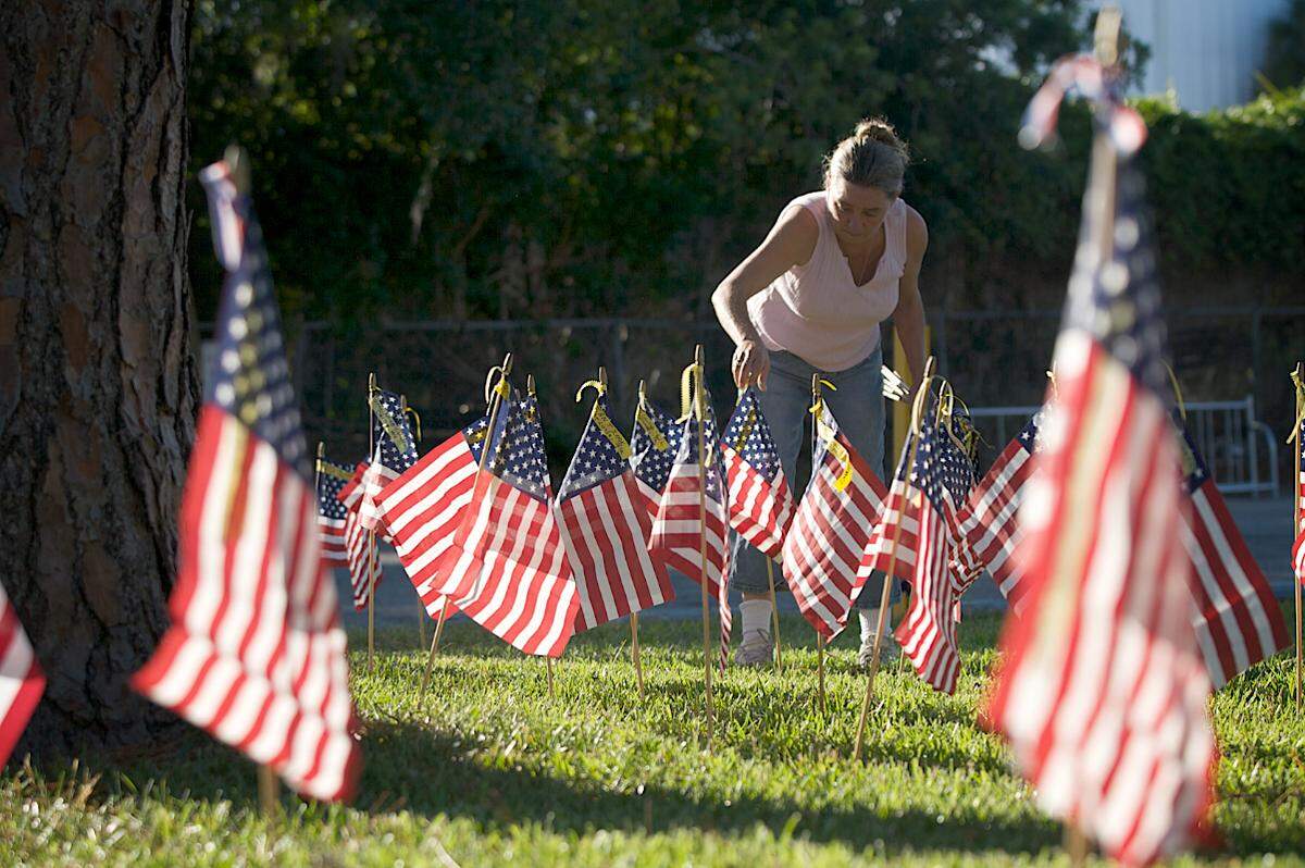 Donna Cummings places flags in remembrance of Florida soldiers who have died in the line of duty in front of the American Legion Christopher R. Cobb Memorial Post 312 for Memorial Day 2011.