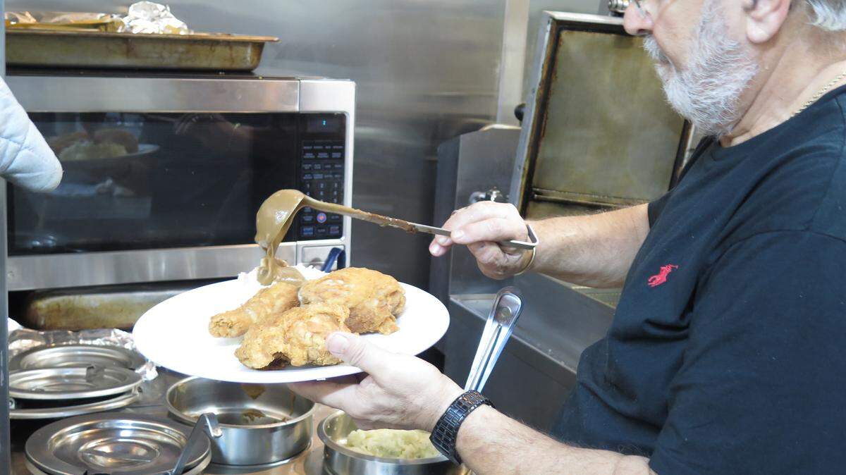 Paul Amato pours gravy over mashed potatoes on a fried chicken plate at new restaurant Paul & Frankie's Country Kitchen on Manatee Avenue. The Amatos owned several restaurants in Manatee County before finding the one where they hope to spend the rest of their lives. JANELLE O'DEA/Bradenton Herald
