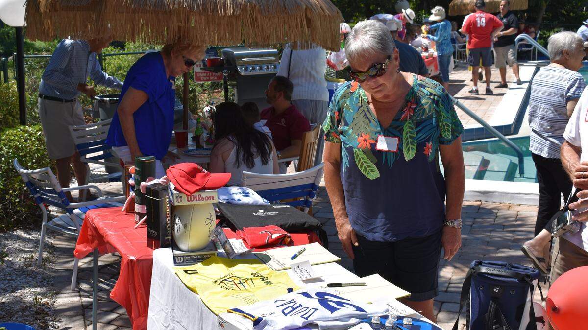 A guest inspects the donated memorabilia at Francesca Friedel’s annual fundraiser for St. Jude’s Children’s Research Hospital. Some of the featured items this year were an autographed Kevin Durant jersey, a game-worn Florida State University football jersey and a 17th hole flag autographed by Phil Mickelson.