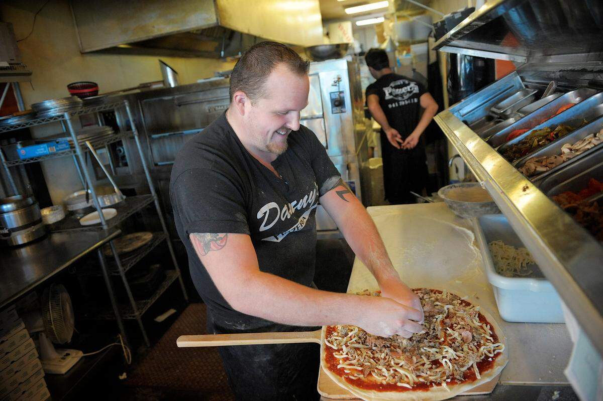 Danny’s Pizzeria pizza guru David Miesner prepares a hand-tossed pizza at the busy restaurant in West Bradenton.