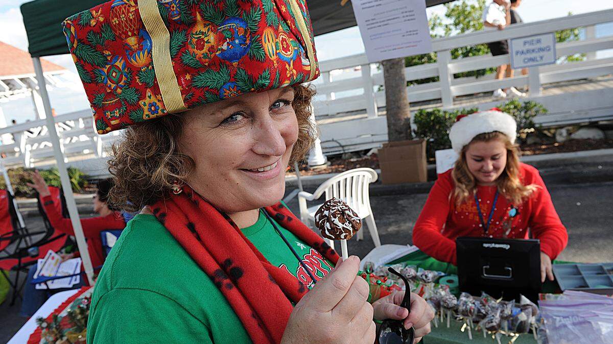 Caryn Hodge smiles after purchasing a chocolate treat from Jewelle Bober, 12, at the Children's Gift Bazaar during the a past Christmas on Bridge Street event in Bradenton Beach. 
 HERALD FILE PHOTO