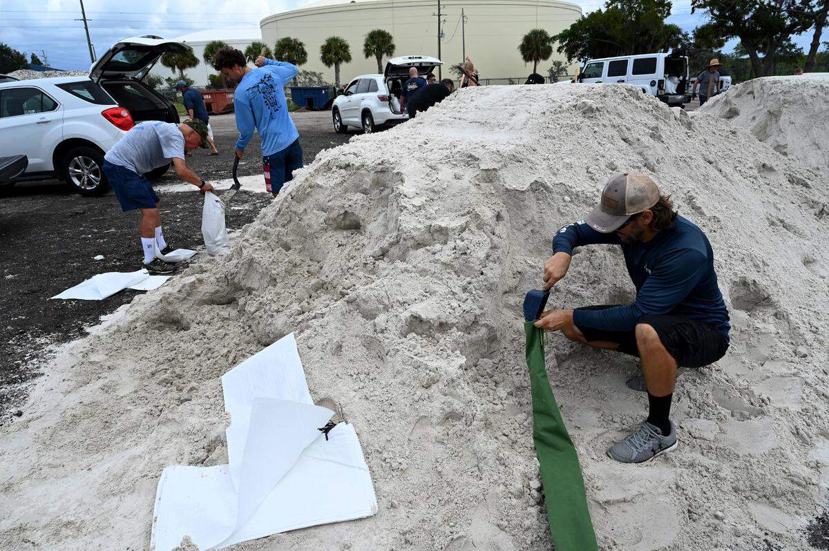 Residents work at the self-serve 66th Street West sandbag location filling bags in preparation for Idalia’s expected strengthening and approach on August 28, 2023.