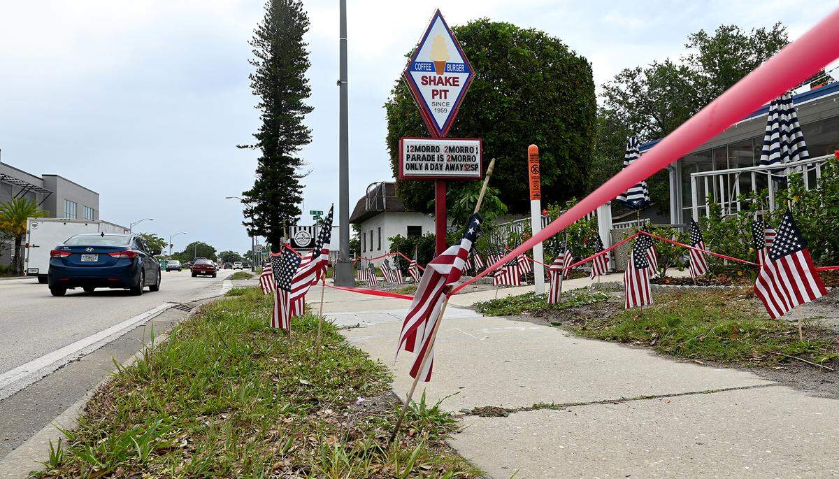 Tape and flags outline ‘reserved’ space in front of the Shake Pit on Manatee Avenue West in anticipation of Saturday night’s De Soto Parade.