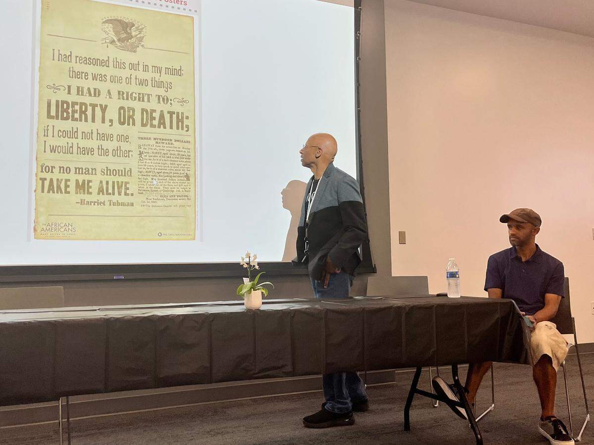 A descendant of Harriet Tubman ,A.J. Brickler III stands in front of a newspaper clip that was an offering a $3,000 bounty for the capture of Tubman when she first escaped from a plantation in Maryland. He presented this clip to a group during a Q&A session hosted by the Family Heritage House on the campus of State College of Florida, Manatee-Sarasota. While his son A.J. Brickler IV looks on. 05,14,2022.