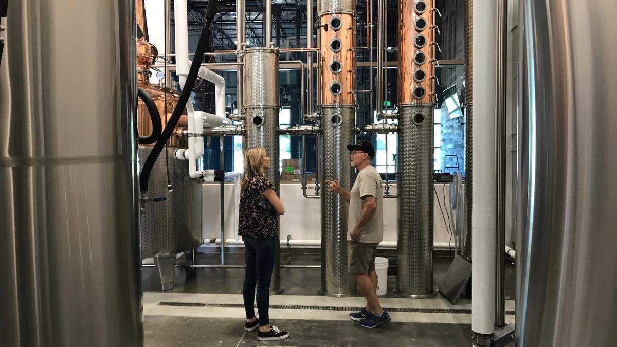 Michelle Russell and Steve Milligan stand among gleaming new equipment Monday at Loaded Cannon Distillery and Tasting Room in Lakewood Ranch.