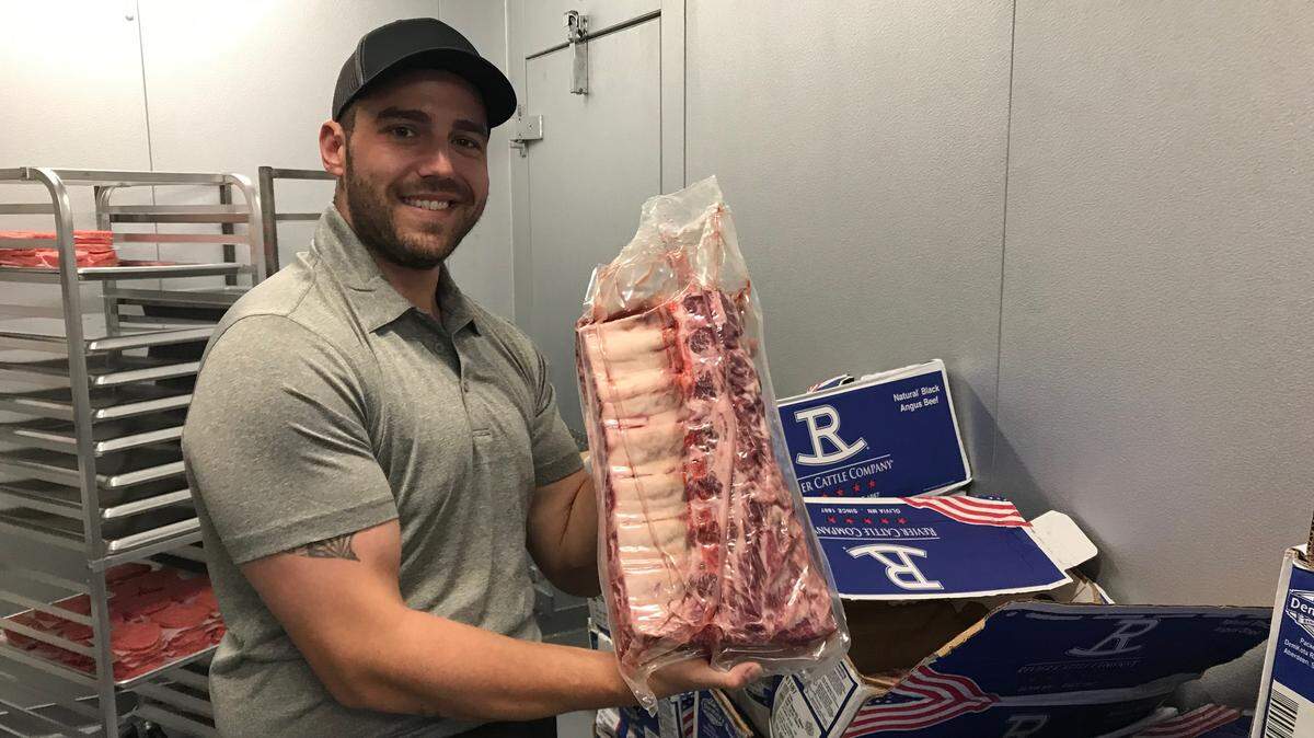 Clark McFarland holds a cut of prime bone-in ribeye at Butcher’s Mark, 8519 Cooper Creek Blvd., University Park. The new store opened Wednesday.