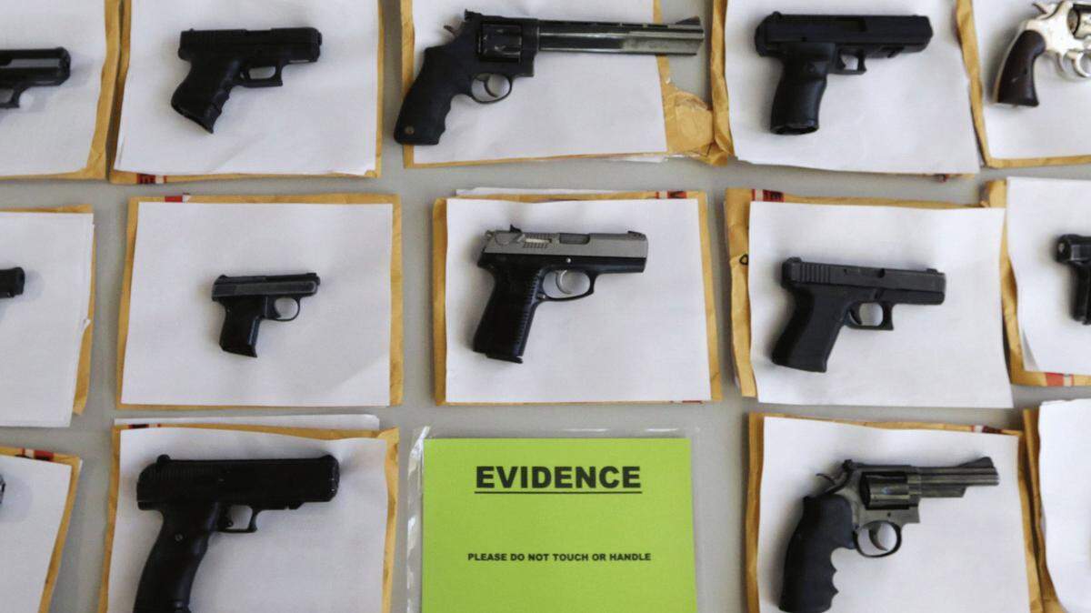FILE - In this Monday, July 7, 2014, file photo, Chicago police display some of the thousands of illegal firearms they have confiscated so far this year in their battle against gun violence in Chicago. The recent mass shooting at an Oregon community college has put the debate over gun violence and gun control into the center of the presidential race. At least some of the Republicans who are running have pointed to Chicago as proof that gun control laws don't work. (AP Photo/M. Spencer Green, File))