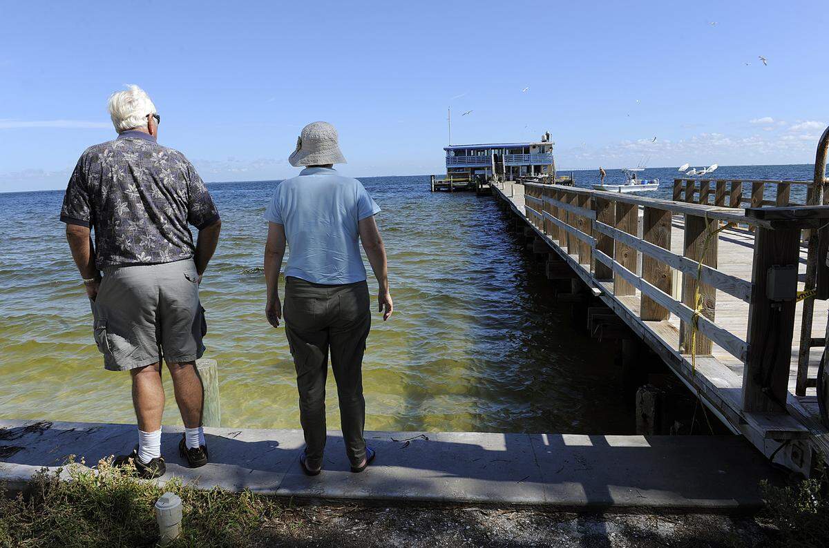 Tourists gaze upon the historic Rod & Reel Pier after it was closed for repairs after a fire broke out in September 2013. Though dismayed, the couple said they would return to the pier next year.