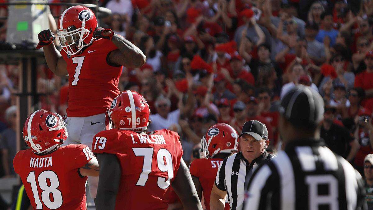 Georgia running back D’Andre Swift (7) celebrates with tight end Isaac Nauta (18) and offensive lineman Isaiah Wilson (79) after scoring a touchdown against Tennessee during the second half Saturday’s game against Tennessee.