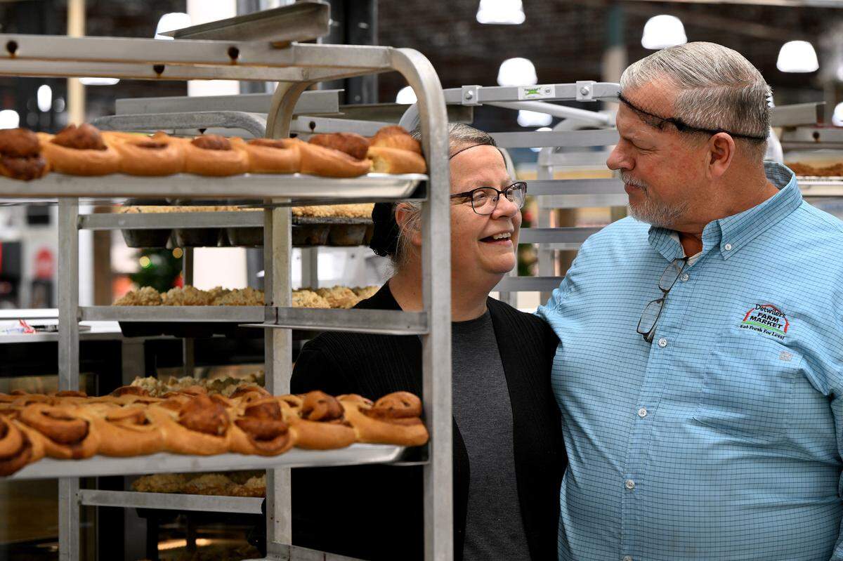 Founder and CEO of Detwiler’s Farm Markets Henry Detwiler and wife Natalie stand beside some freshly-baked cinnamon buns in the newest store in Bradenton.